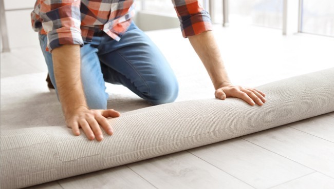 Man rolling carpet for installation | CarpetsPlus COLORTILE of Hutchinson